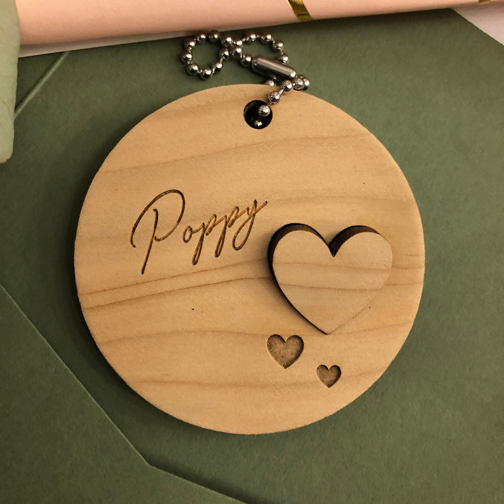 Wooden round decoration with a name and cut out heart