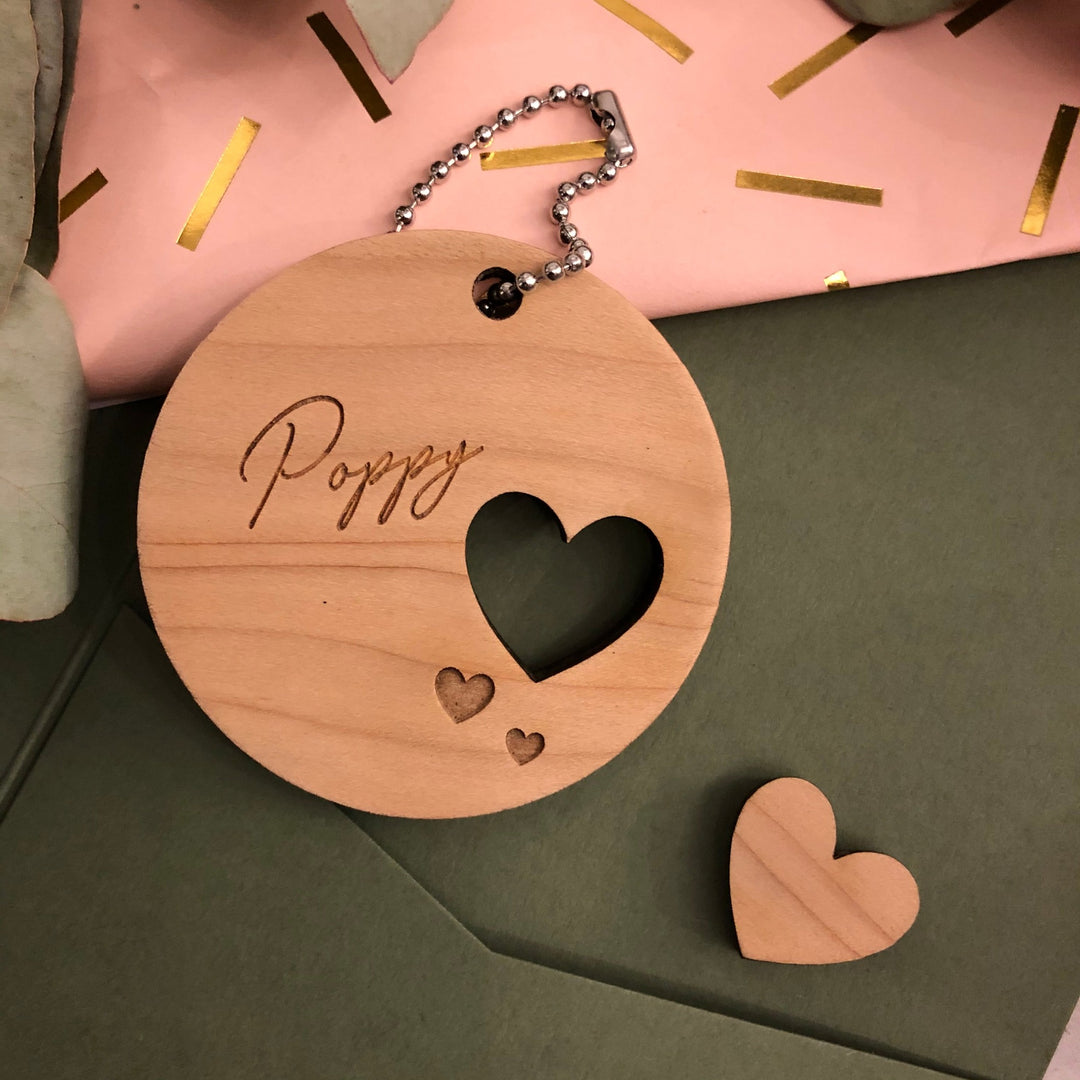 Wooden round decoration with a name and cut out heart
