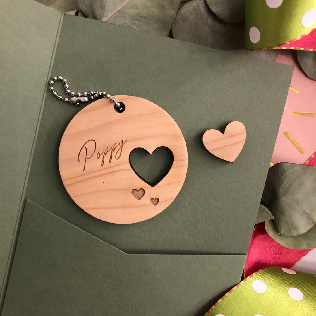 Wooden round decoration with a name and cut out heart