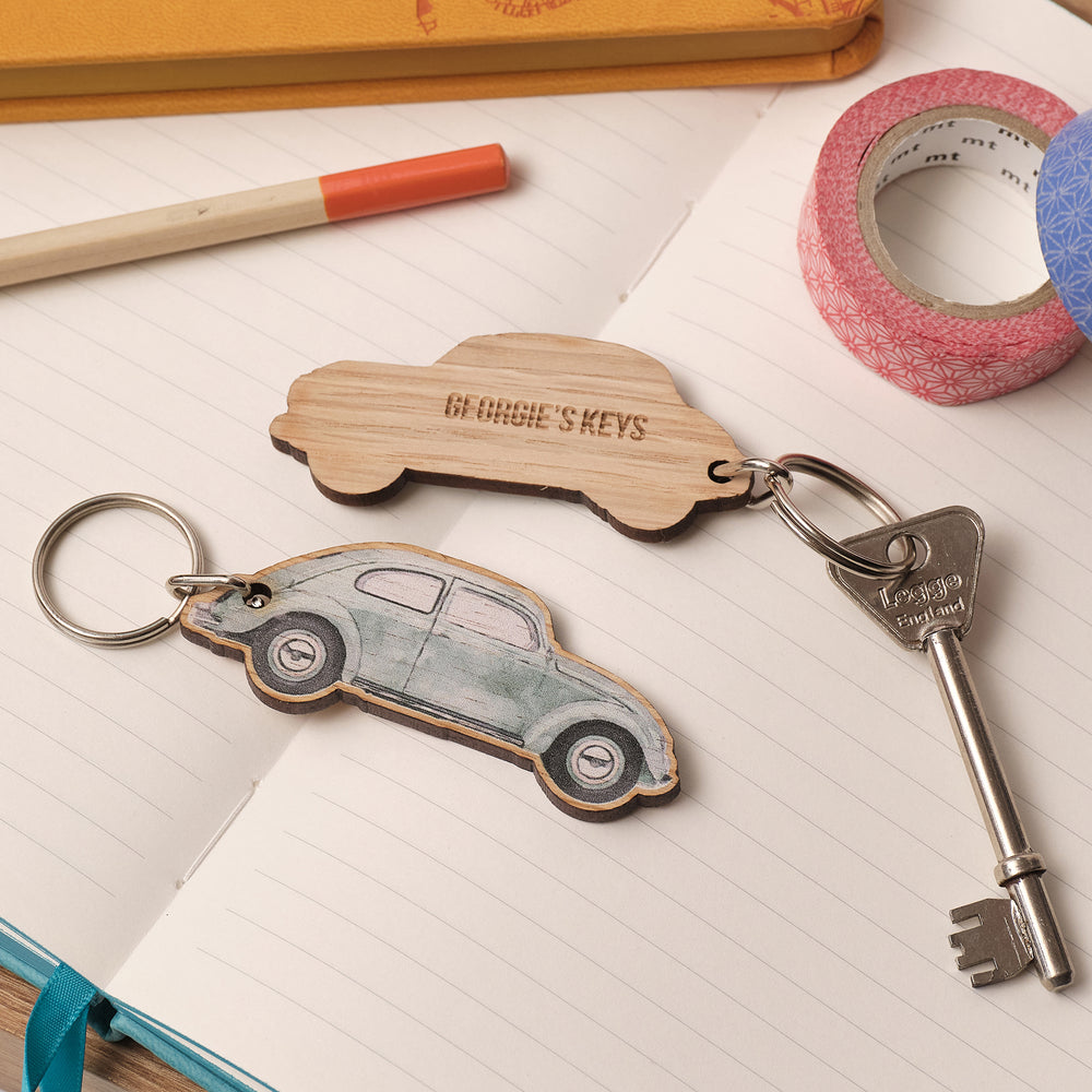 Personalised wooden pale green VW Beetle car gift keychains keyrings a notebook with tape and a pen. Great travel gift or gift for dad. Personalised text engraved on the back saying 'Georgie's keys'.