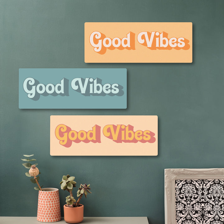 Positive quote wooden wall art reading Good Vibes, adding charm to a hallway with sage green accents and photo tiles.