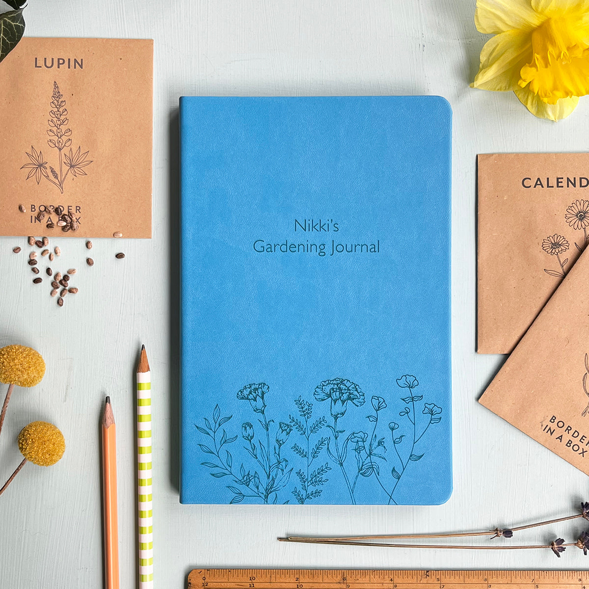 Blue luxury notebook engraved with a floral pattern and personalised text