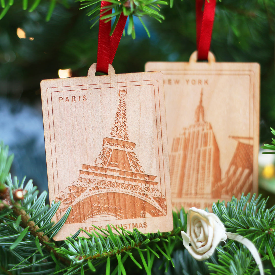 Choose your own location and text in these sustainable personalised wooden Christmas tree decorations ornaments with Eiffel Tower and Empire State Building designs hanging on a tree. Would make  a perfect laser cut bespoke wedding or honeymoon destination gift for newlywed couples.