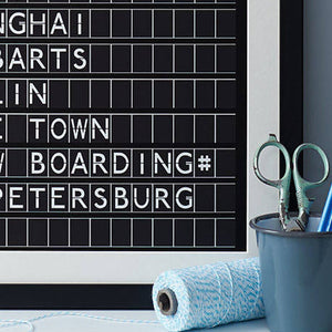 Close up of Black framed black and white print in the style of an airport departures board