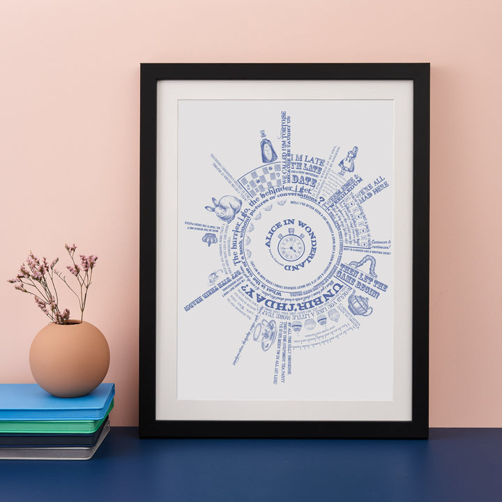 Framed print with blue typographic text printed in a circular design with quotes from the book Alice in Wonderland