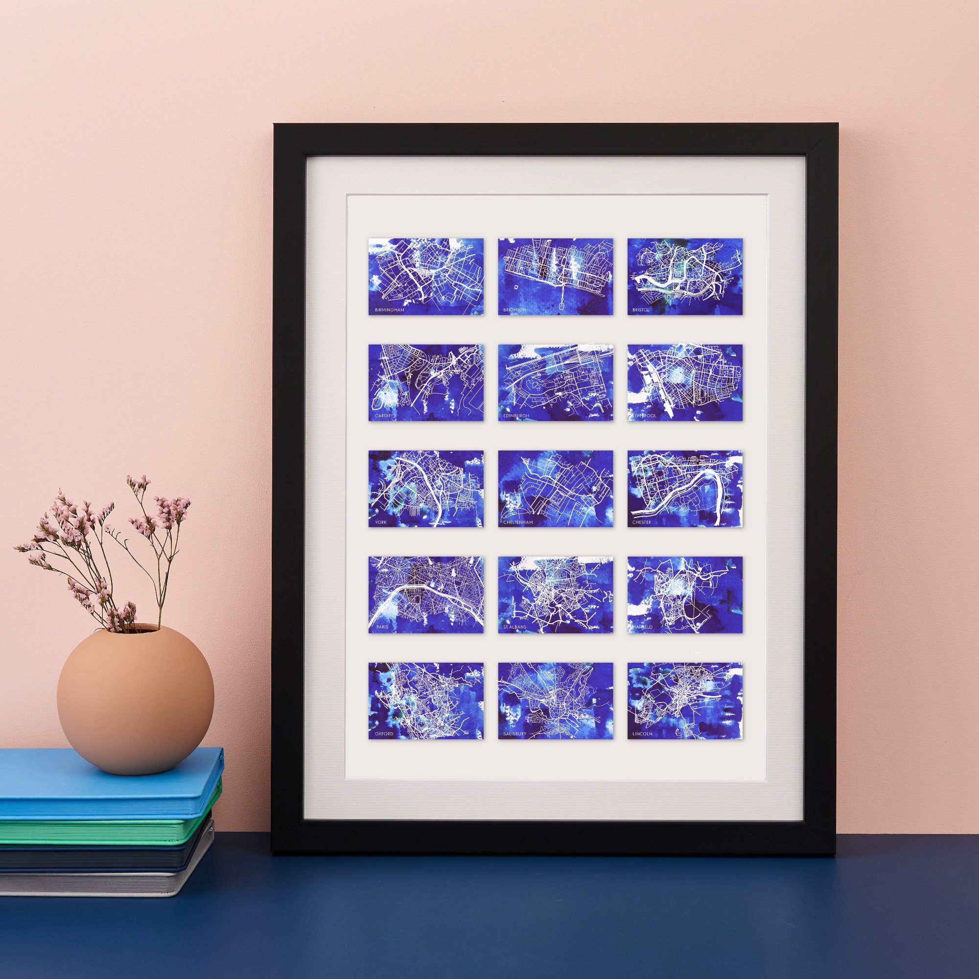 Black framed print with 15 small blue maps of different locations
