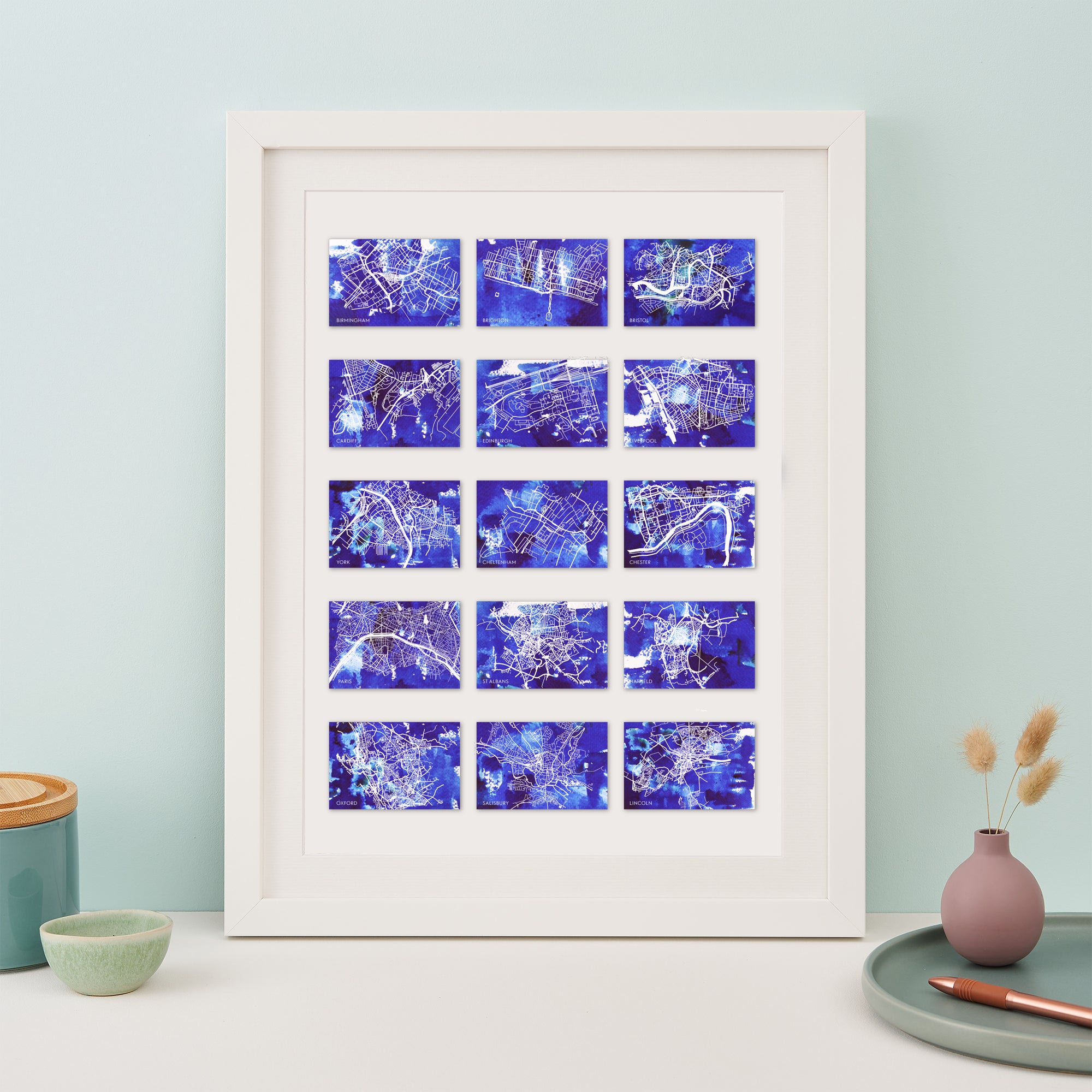 framed print with 15 small blue maps of different locations