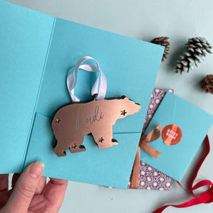 Bronze coloured polar bear Christmas tree decoration engraved with a name in a turquoise card gift sleeve
