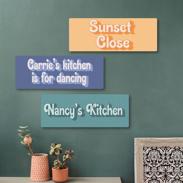 Ideal gift to commemorate a new kitchen or a new home, three decorative signs with text on a green wall, with plants and a framed picture in the foreground. Wall art prints made in the UK, would work well as a door hanging!