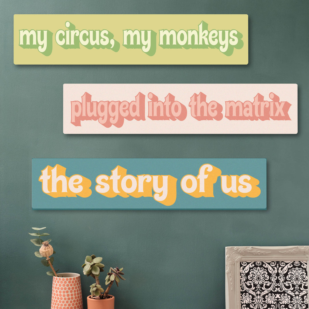 Three colourful rectangular signs with personalised text on a green wall, with plants and a framed picture in the foreground. Funky quirky wall art that will make your guests smile, great gift for Mothers day or wife gift.