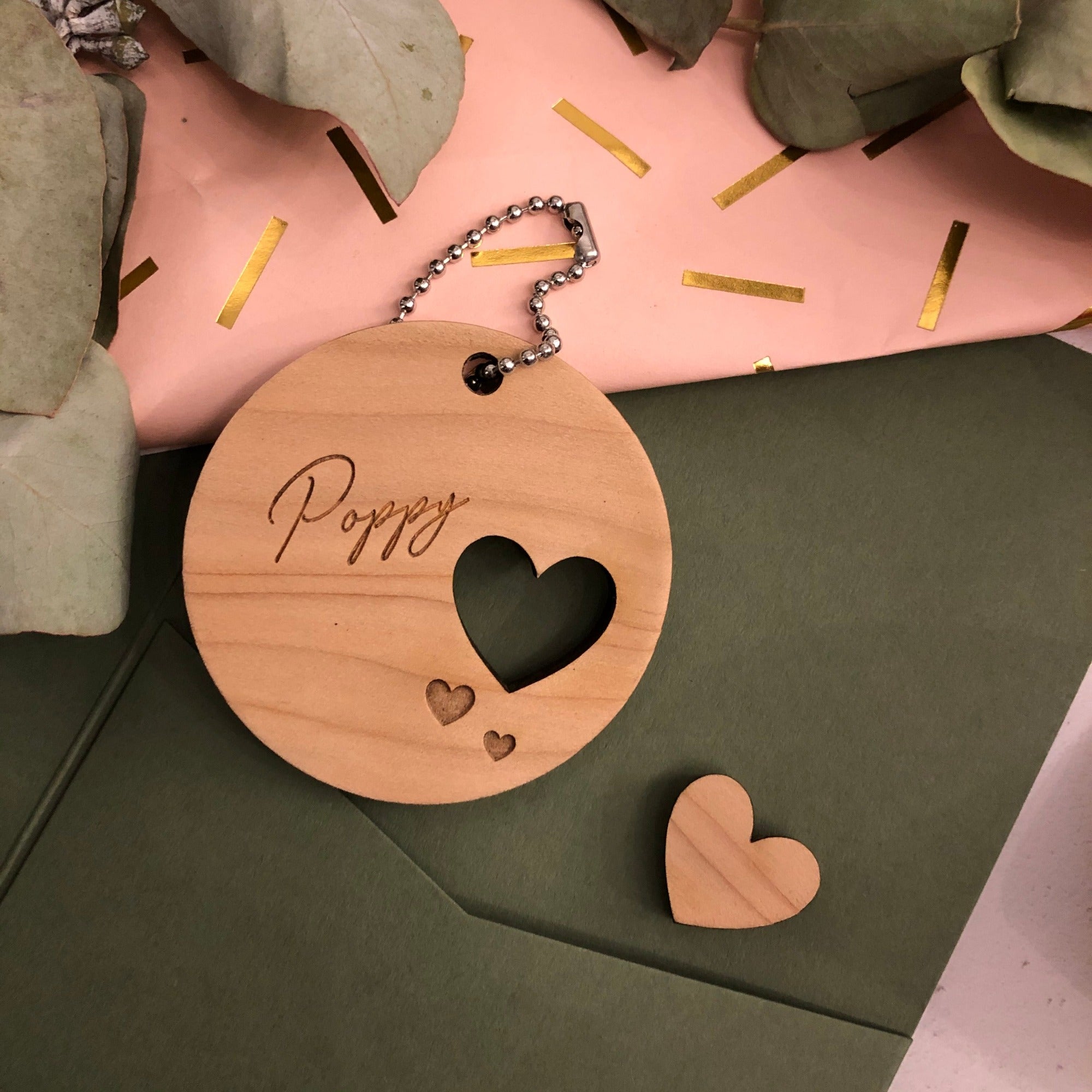 Wooden round decoration with a name and cut out heart