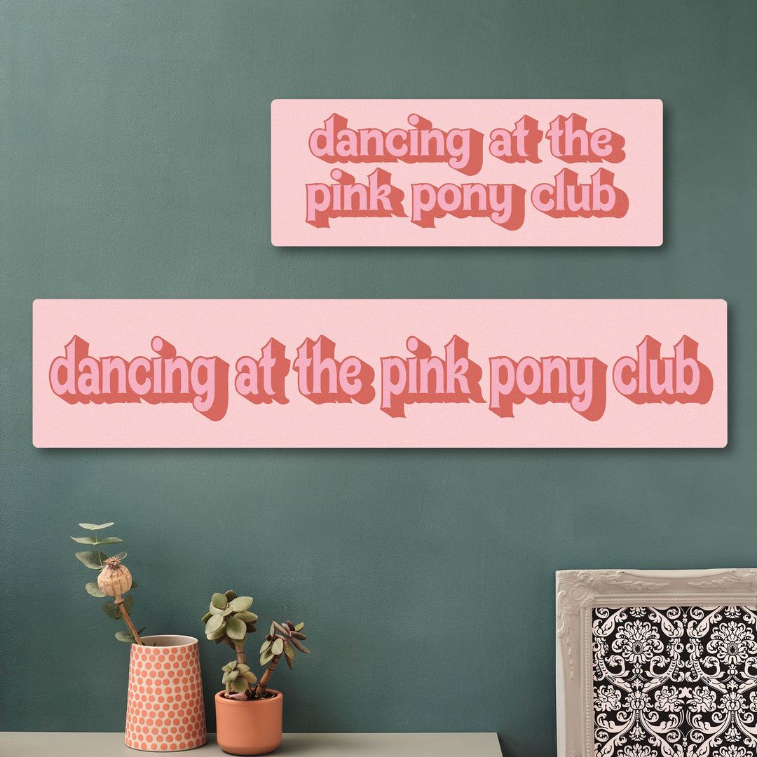 Two personalised pink signs with 'dancing at the pink pony club' text on a green wall. Perfect for teenager bedroom gift for daughters.