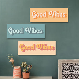 Positive quote wooden wall art reading Good Vibes, adding charm to a hallway with sage green accents and photo tiles.