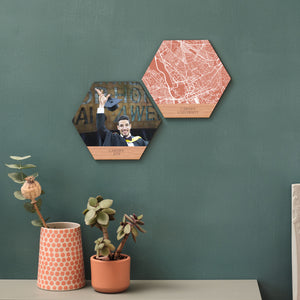 Two hexagons create a mini gallery of college wall art. One shows a young man in cap and gown, throwing his hat in the air. One shows a map of Cardiff University. Displayed on a green wall.