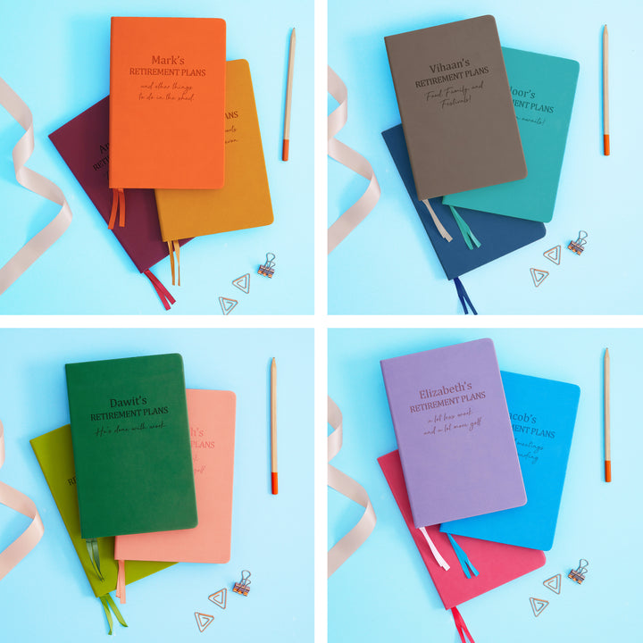 The image shows examples of personalised engraved text on all 12 colours of notebook. The books are stacked in threes and are surrounded by various pieces of stationery.