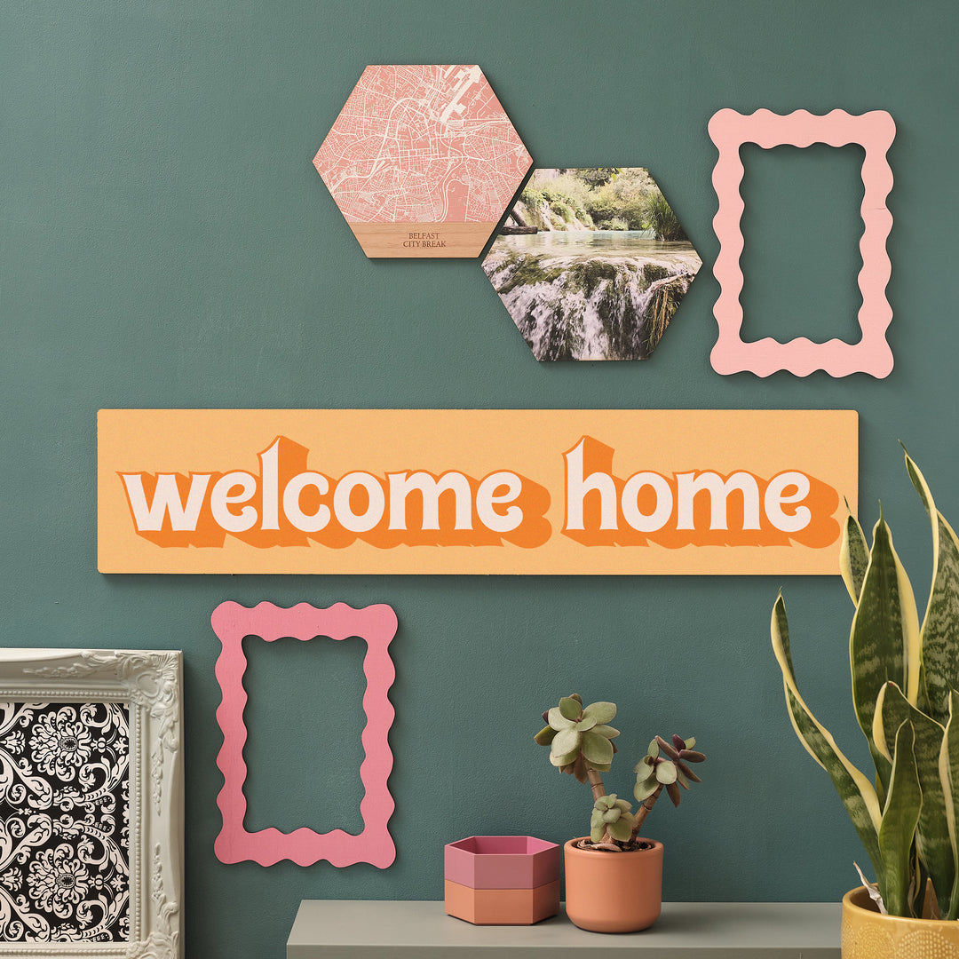 Homecoming wall decor with orange Welcome Home sign and pink accents