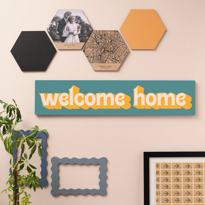 retro-style welcome sign paired with gallery wall and houseplants