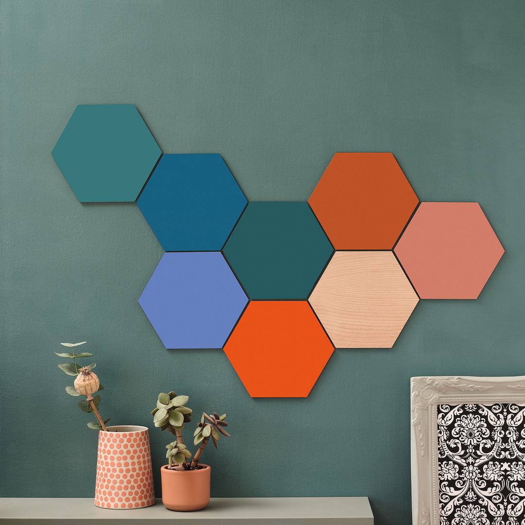 Vibrant colourful wooden wall arts in a variety of modern colours tessellated into a unique modern maximalist renter friendly gift shape on a green wall.