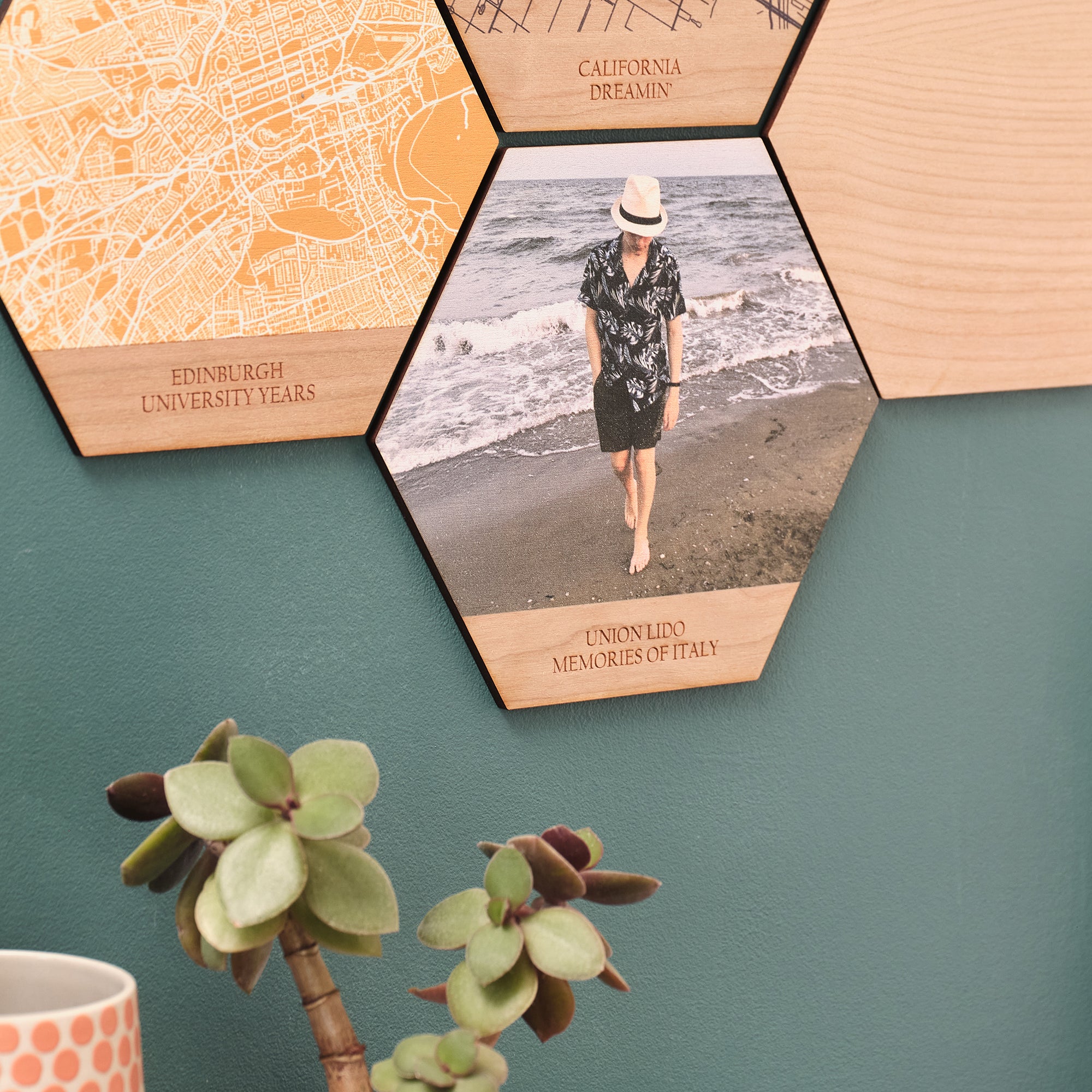 A close up shot of a group of four wooden hexagonal picture tiles. They feature an image of a boy, a map of Edinburgh, and a map of California.