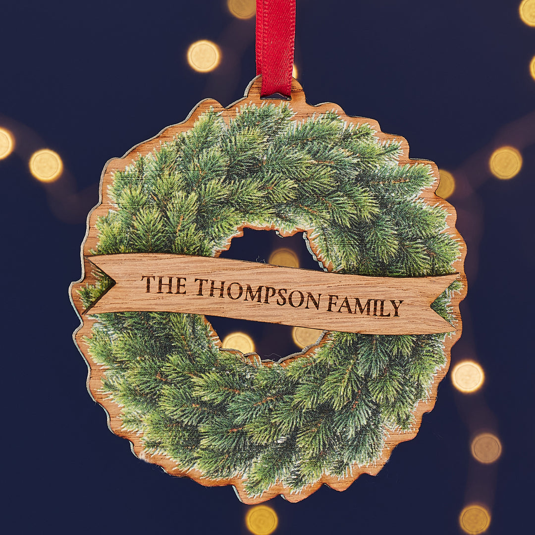 Wooden wreath Christmas ornament customised with couple or family names for festive tree décor.