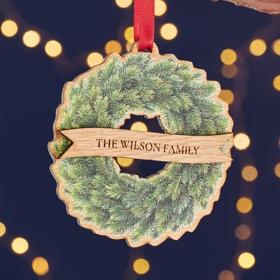 Engraved oak wood wreath bauble, a unique personalised Christmas ornament for family or friends.