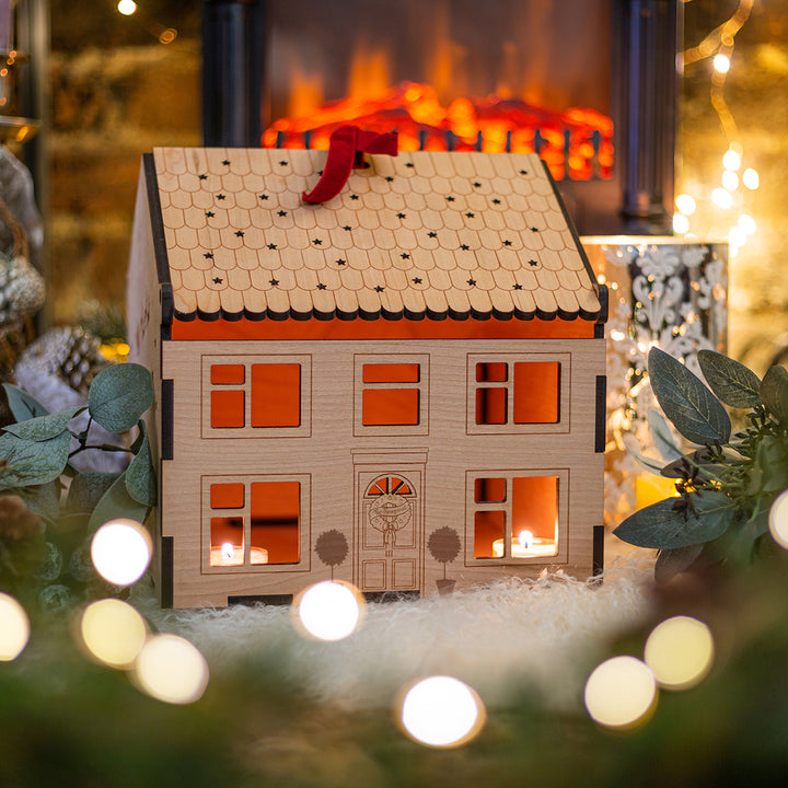 The front of the box with carefully engraved details, such as a wreath and windows with lit candles inside. 