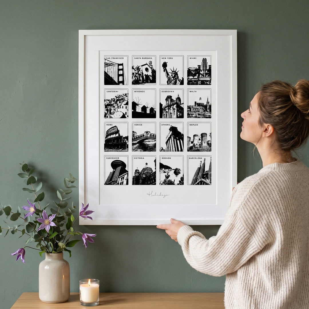 Woman admiring a framed collage of black and white cityscapes on a green wall.