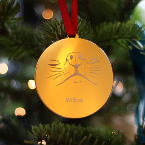 Luxury gold dog nose and whiskers Christmas tree bauble. Hanging on a Christmas tree from a red satin ribbon.