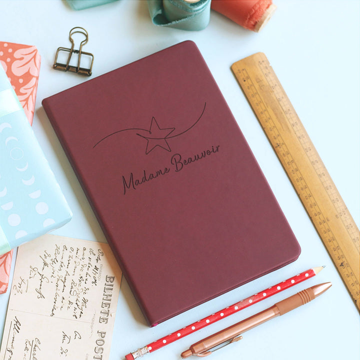 Colourful star motif fun whimsical notebook teacher gift on pale grey background, primary school best teacher ever, surrounded by stationery.