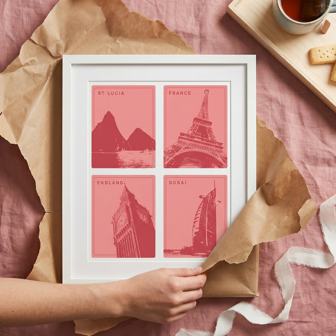 Framed print with four pink illustrations of famous landmarks on a pink surface with brown paper and a cup of tea.