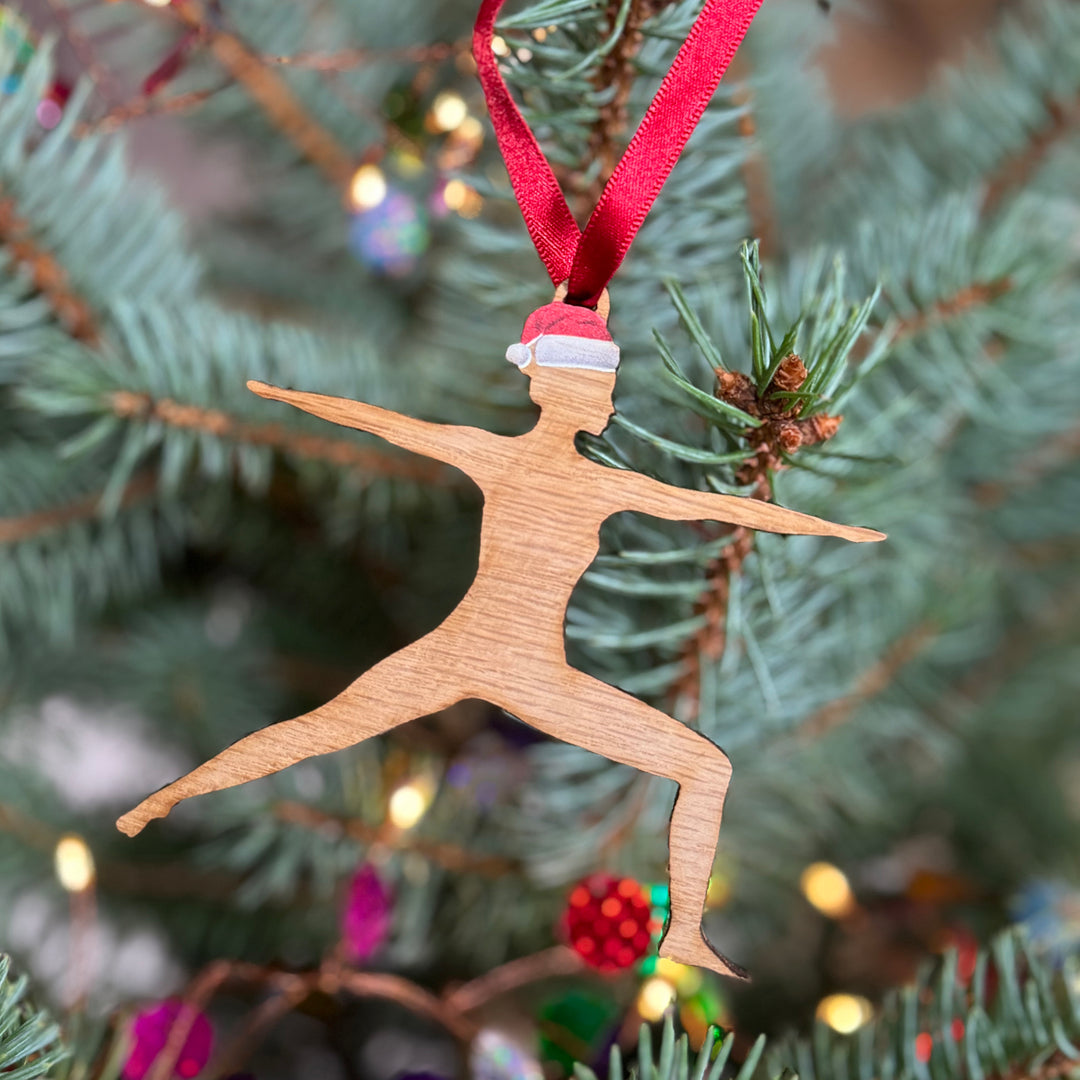 Yoga instructor wooden Christmas tree sporty gift for her, sustainable cherry silhouette with red ribbon and red Santa hat hung on an Xmas tree.