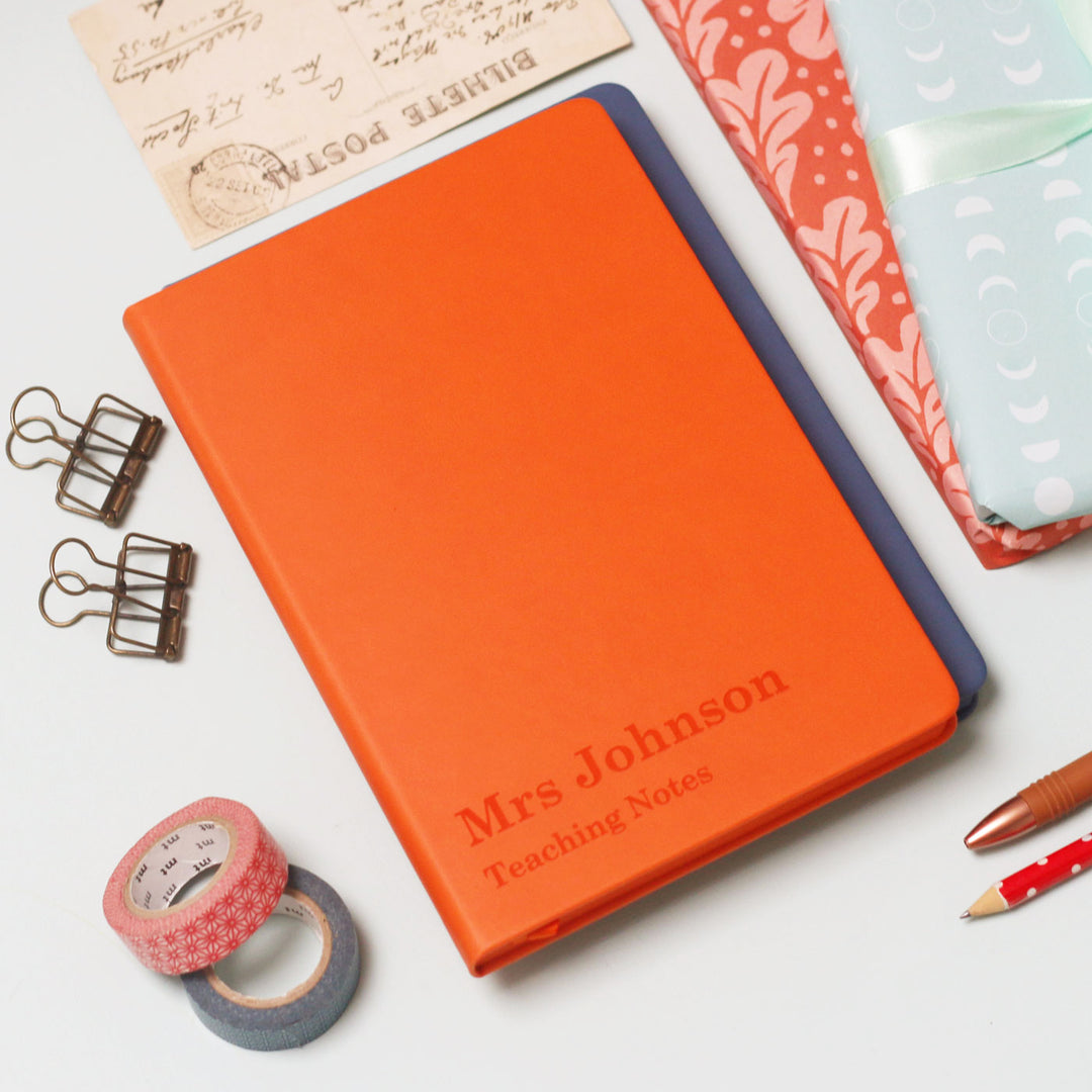 A vibrant notebook journal with engraved text with a teachers name followed by 'Teaching notes' on a modern background, perfect end of year gift for teachers.