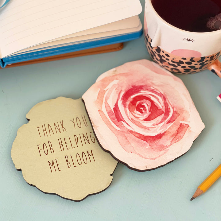 Two wooden coasters, one with a watercolor floral design and the other with a personalized message: "Thank you for helping me bloom."
