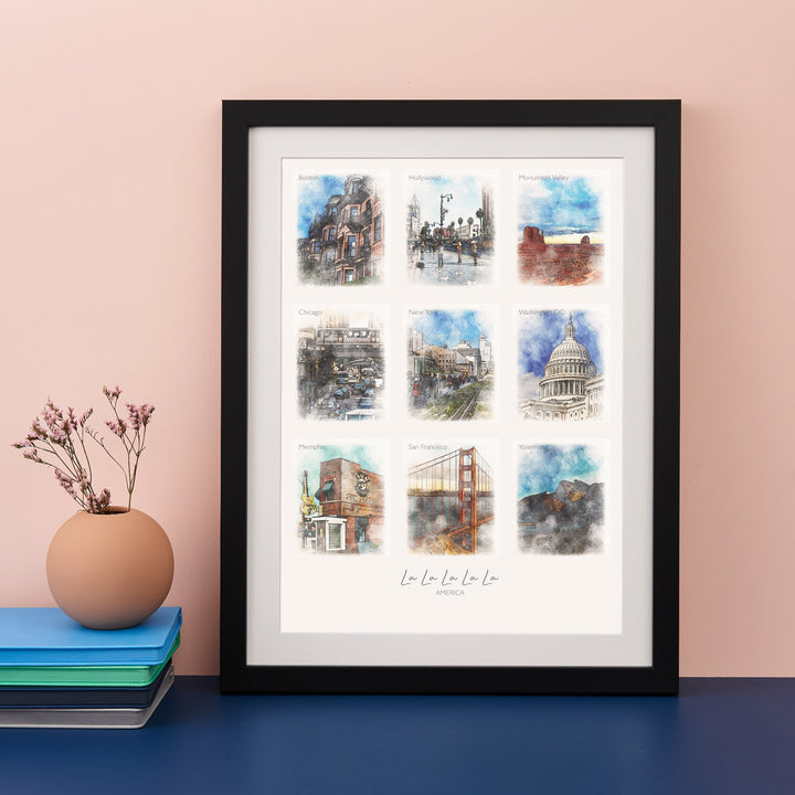 A framed print with nine watercolor paintings of famous landmarks: Hollywood, San Francisco, Monument Valley, Chicago, New York, Washington DC, Las Vegas, San Francisco, and Hollywood. The text "La La La La La" and the year "2019" are written below the images.