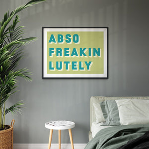 Black framed typographic print saying Abso Freakin Lutely on a green background