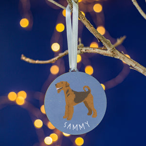 Blue round tree decoration with a painting of an airedale terrier on the front