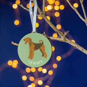 Green round tree decoration with a painting of an airedale terrier on the front