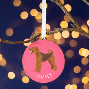 Pink round tree decoration with a painting of an airedale terrier on the front