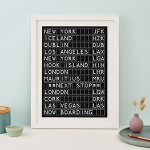 White framed black and white print in the style of an airport departures board