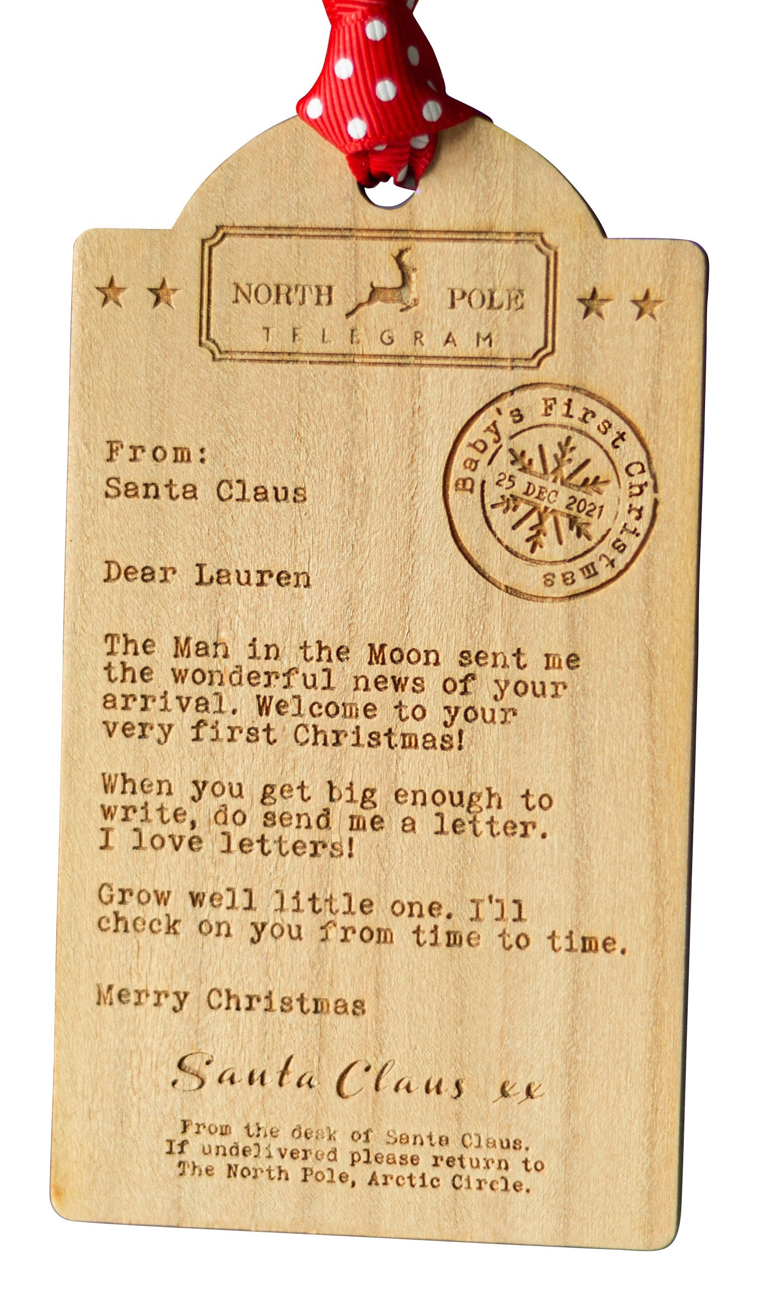 Cut out image of a luggage tag shaped Wooden decoration engraved with a typed message from Santa Claus 