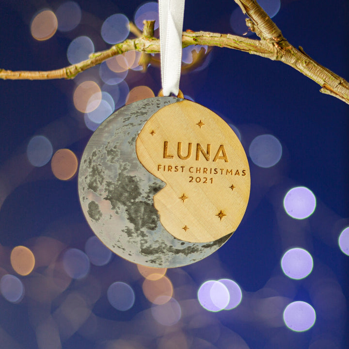 Wooden round Christmas tree decoration with a silver crescent  moon and personalised text. First Christmas for baby