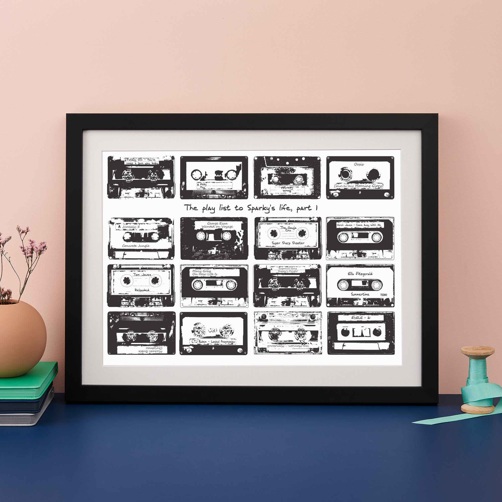 Framed print with 16 monochrome music cassettes on a white background and personalised text. 