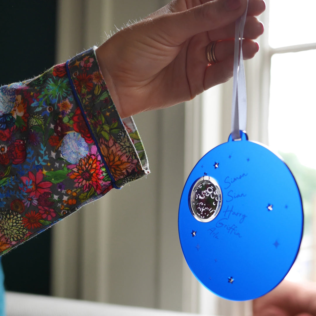 Dark blue frosted acrylic Christmas decoration with moon and stars design.