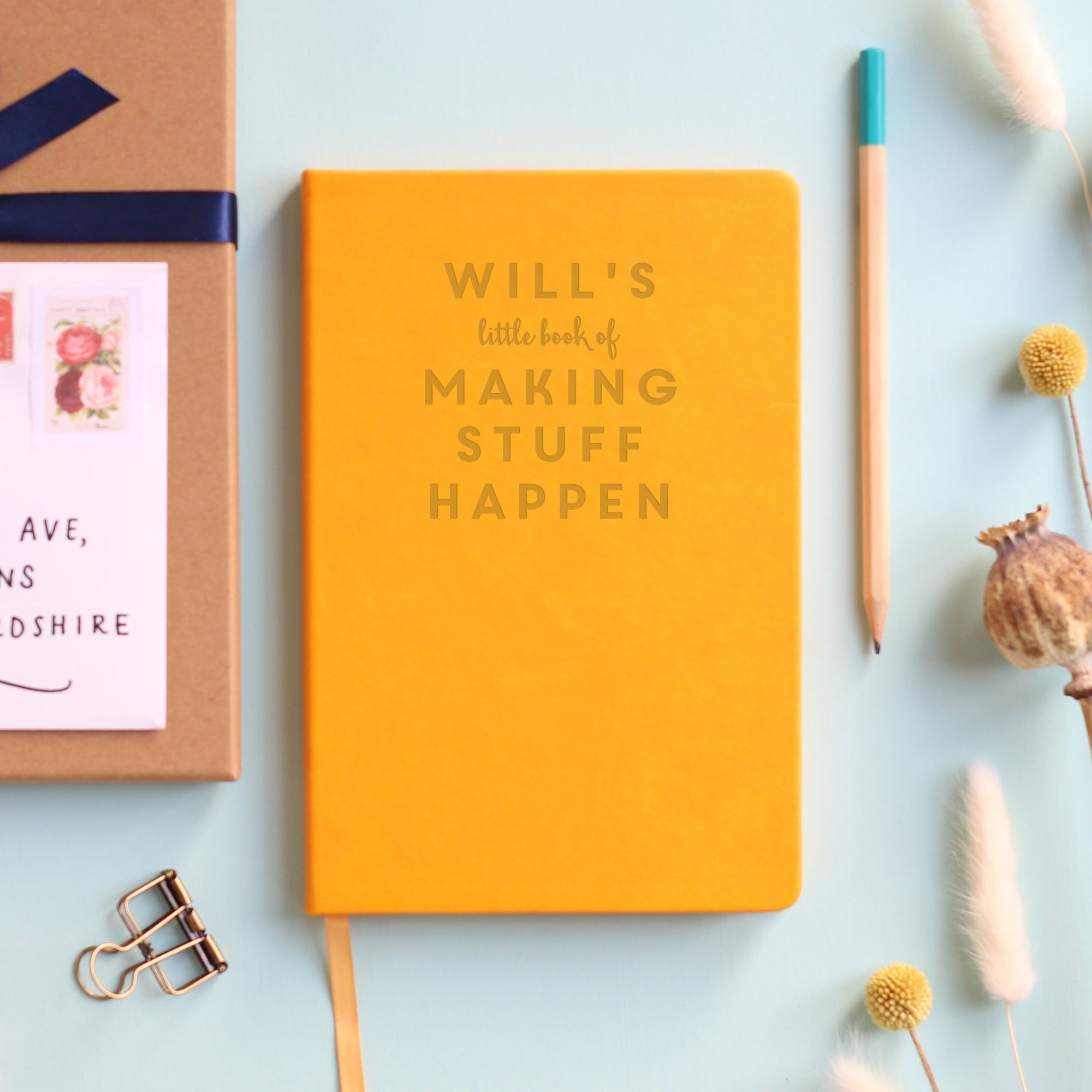 Mustard colour notebook engraved with the words Will's little book of making stuff happen