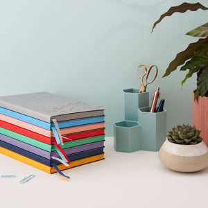 Colourful stack of notebooks showing edges have same colour as front of book