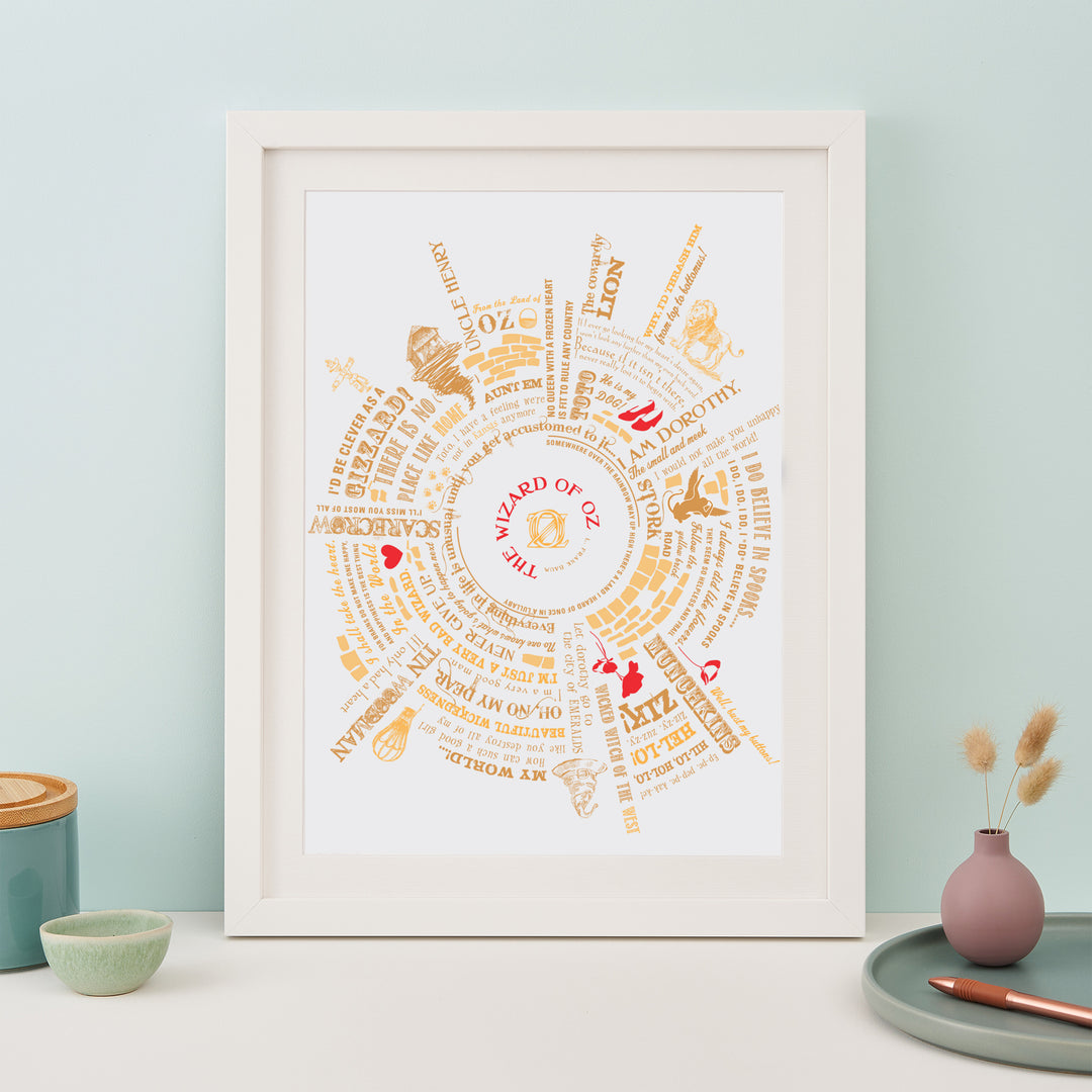 Framed The Wizard of Oz typographic art print with gold and red accents, displayed on a pastel-colored wall.