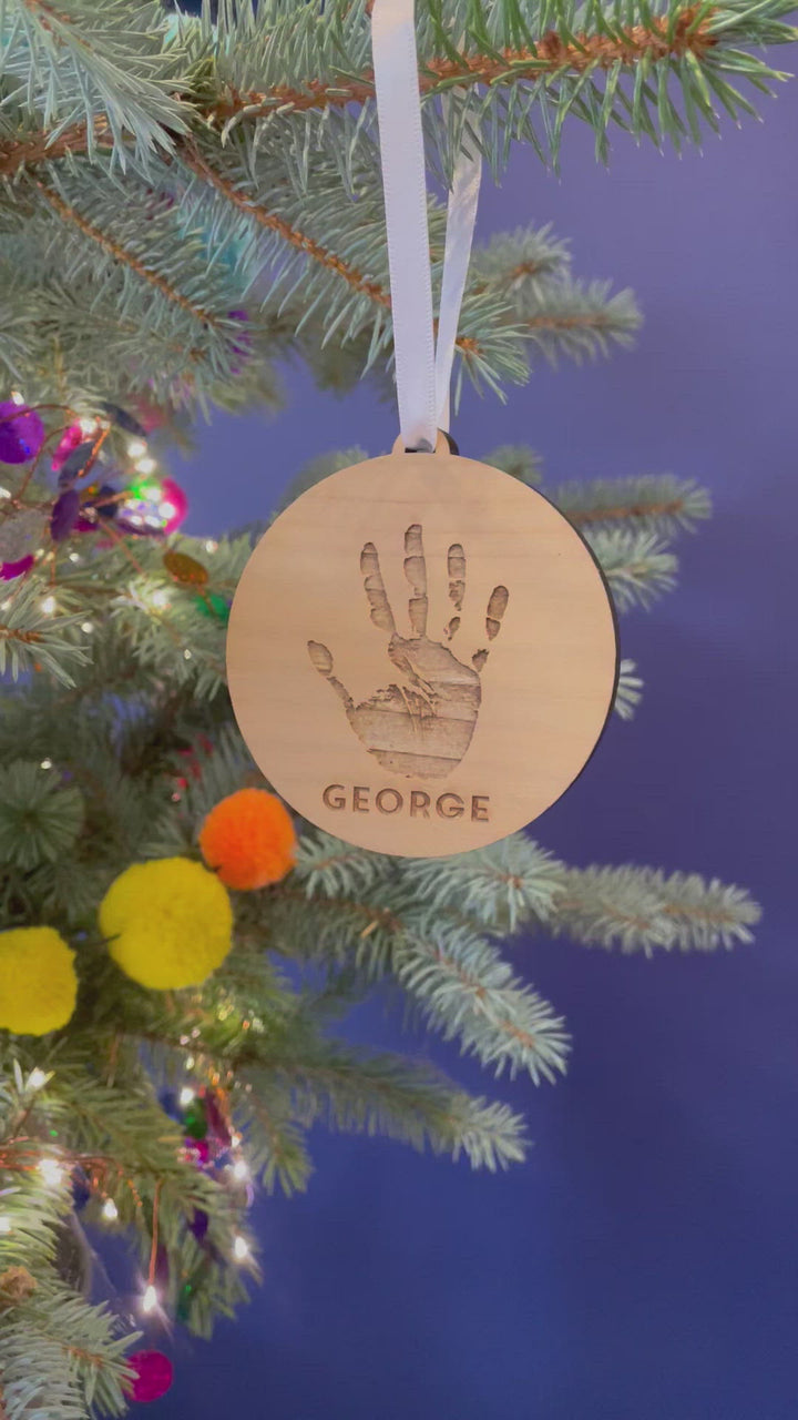 A video showing the decoration from different angles, hanging from a Christmas tree by a white satin ribbon.
