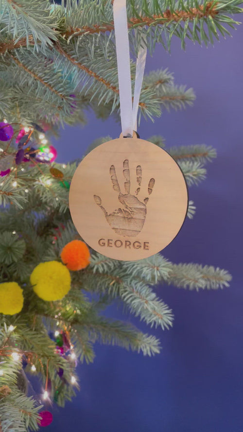 A video showing the decoration from different angles, hanging from a Christmas tree by a white satin ribbon.