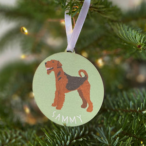 Green round tree decoration with a painting of an airedale terrier on the front