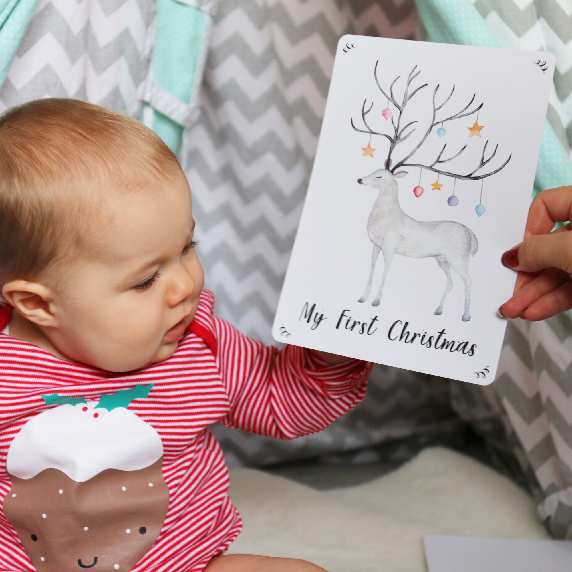Cute baby looking at a reindeer print